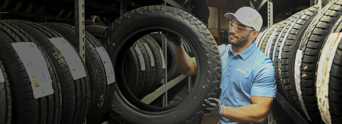 A Tire Nation Point S technician selecting a tire from the rack